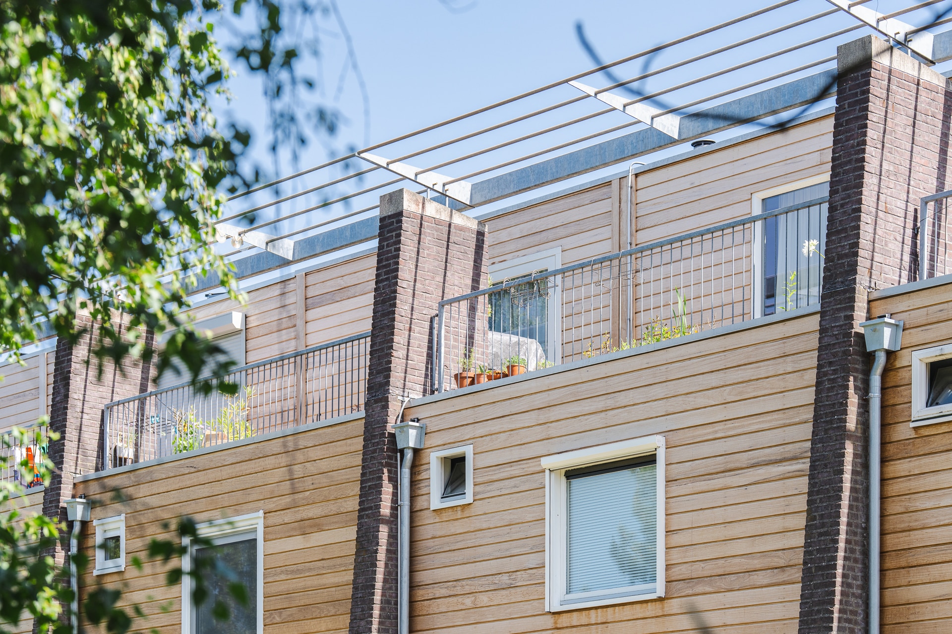 Nahaufnahme der Thermo-Fraké Fassadenverkleidung mit Balkon und Dachterrasse